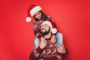 Fototapeta premium Dad with small adorable sweet cute girl fooling around, excited in knitted traditional x mas costumes with ornament, head wear, december, noel time, celebrate, winter mode