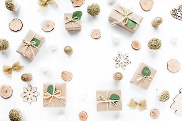 christmas toys and craft boxes on white background. creative arrangement frame of craft boxes and green branches eucalyptus on white background. flat lay, top view