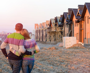Rear view of young couple looking at their new house.