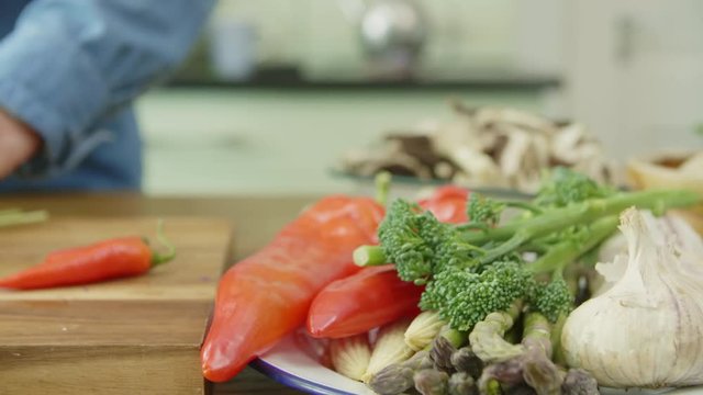 Vegetables In Plate By Man Cutting Spring Onion At Kitchen