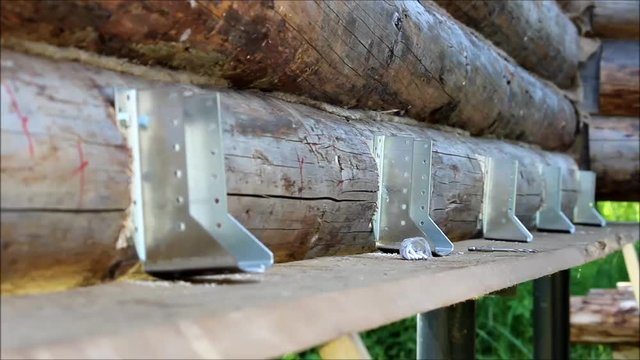 Assembling a wooden frame and building a house. Russia. The worker screw the screws into the pre-drilled holes with a screwdriver.