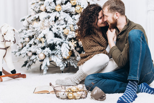 Fashion photo of christmas kissing couple. Sitting down. Christmas and New Year concept