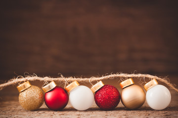 Vintage garland with Christmas balls toys on the old wooden background, toned