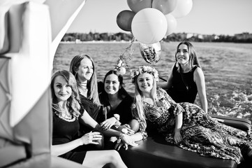 Fototapeta na wymiar Five girls wear on black having fun at yacht against lake at hen party.