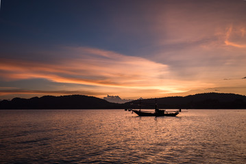 Thai taxi boat at sunset in Andaman sea Thailand.