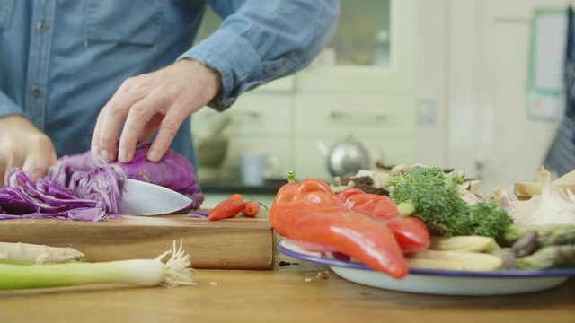 Vegetables In Plate By Man Cutting Red Cabbage At Kitchen