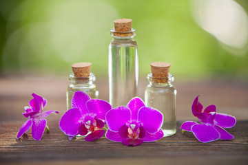 Essence of orchid flowers on table in beautiful glass jar