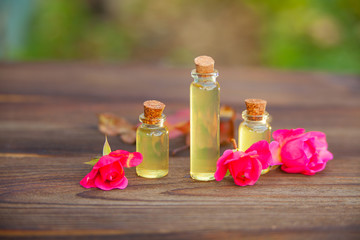 Essence of rose on table in beautiful glass bottle