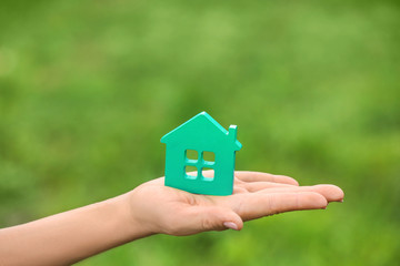 Woman with figure of house on blurred background