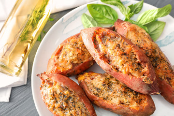 Plate with yummy stuffed sweet potato on kitchen table