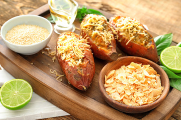 Yummy stuffed sweet potato on wooden board