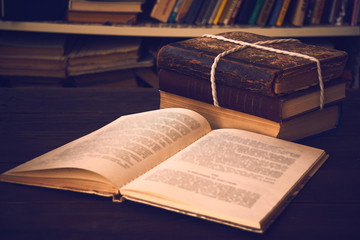 open book on library desk with books stacked in the background