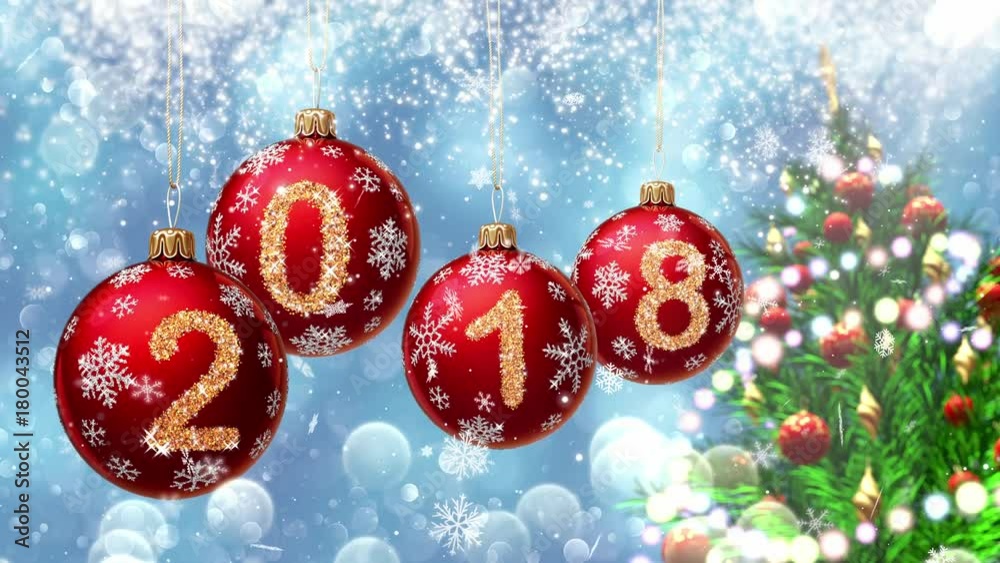 Wall mural red balls with numbers 2018 hanging on the background of a blue bokeh and a rotating christmas tree 