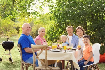 Fotobehang Happy family having barbecue party outdoors © Africa Studio