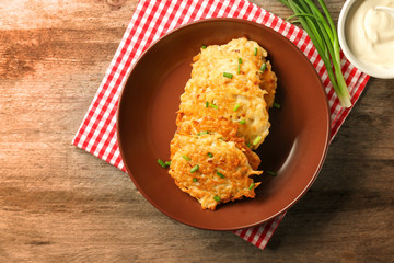 Plate with Hanukkah potato pancakes on table