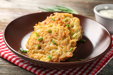 Plate with Hanukkah potato pancakes on table