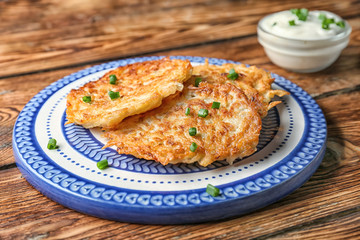 Plate with Hanukkah potato pancakes on table