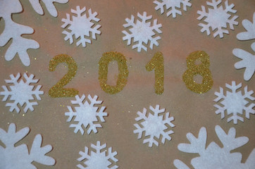 2018 with christmas decoration. concept of the new year and christmas. gold figures 2018 on the background of snowflakes on kraft paper.