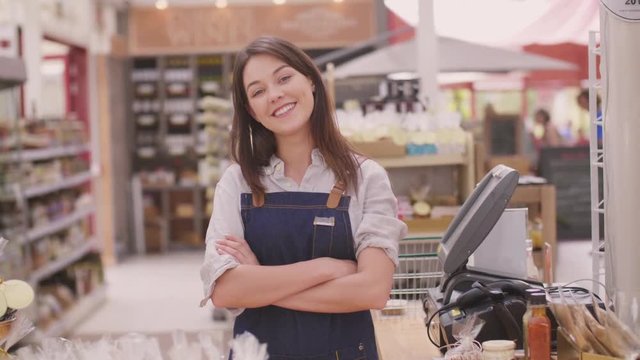 Happy Deli Owner Standing With Arms Crossed At Checkout Counter