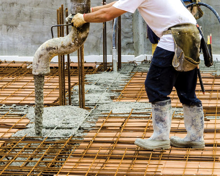 Workers pouring concrete on big floor construction on the construction site,  with motion blur