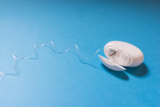 Dental Floss Dispenser For Mouth Hygiene Isolated On The Blue Background