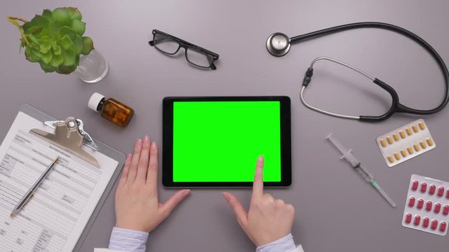 Overhead Shot Of Doctor Using Tablet Computer With Green Screen