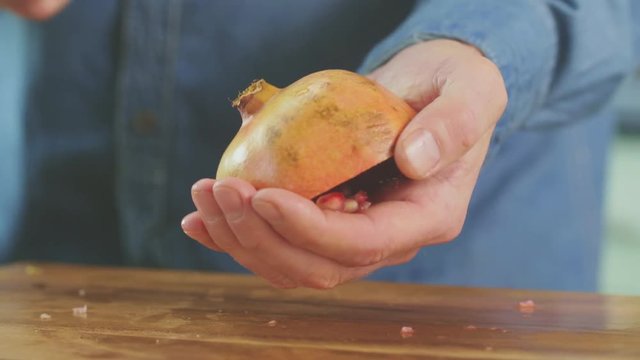 Man Banging Back Of Pomegranate With Spoon To Release Seeds