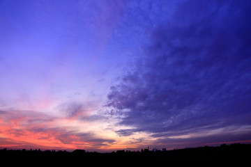 Fototapeta na wymiar Czerwony zachód słońca i granatowe chmury.