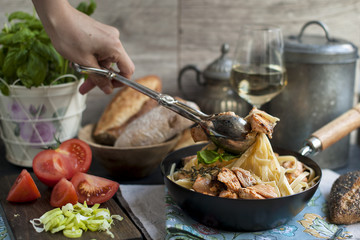 black frying pan with pasta, vegetables and bread for lunch. Hand in frame