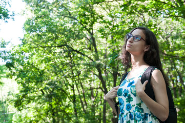 Fototapeta premium Girl tourist in the forest looking up