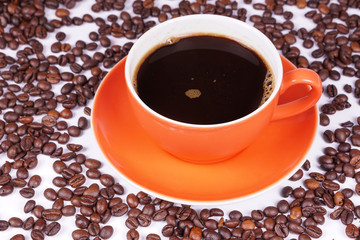 Orange coffee cup on coffee beans