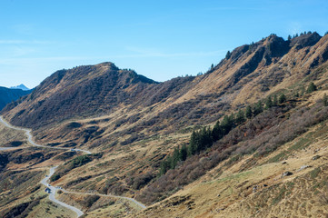 Passstrasse mit parkenden Autos und Herbstlandschaft
