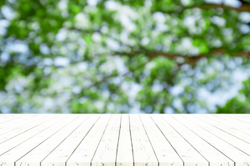 Perspective white wooden table on top over blur natural background, can be used mock up for montage products display or design layout.