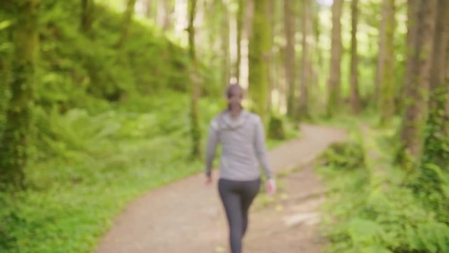 Fit Woman Walking On Narrow Trail In Forest