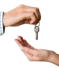 Hand giving set of house keys on light background