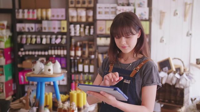Young Deli Owner Using Digital Tablet In Delicatessen