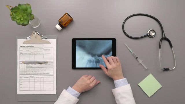 Overhead Top View Of Doctor Examining Spinal Xray On Digital Tablet