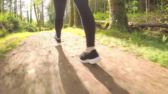 Tracking Shot Of Fit Female Athlete Walking On Forest Trail