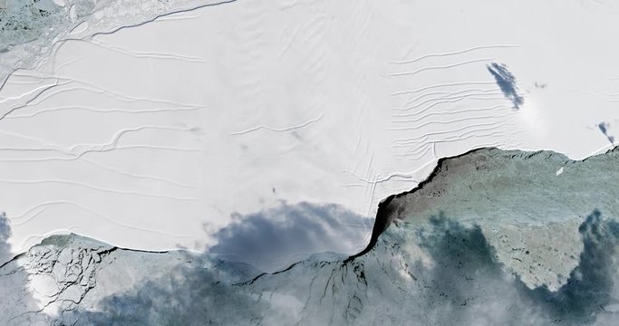 Very high-altitude overflight aerial of iceberg A-68 calving on the Larsen ice shelf, Antarctica. Clip loops and is reversible. Elements of this image furnished by USGS/NASA Landsat