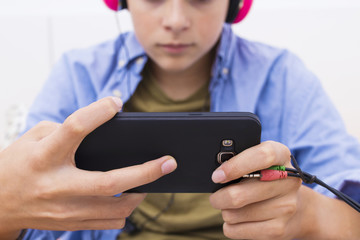 young teenager with a mobile phone listening to music or playing
