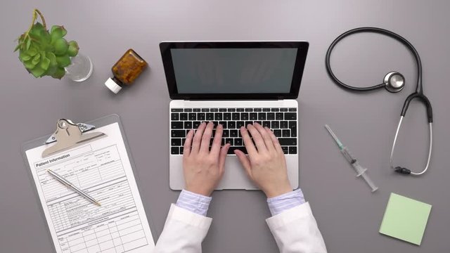 Top View Overhead Footage Of Female Doctor Using Laptop At Desk
