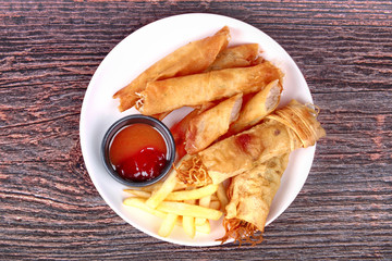 Deep fried spring roll,and frence fries sreved with tomato souce and chili sauce.