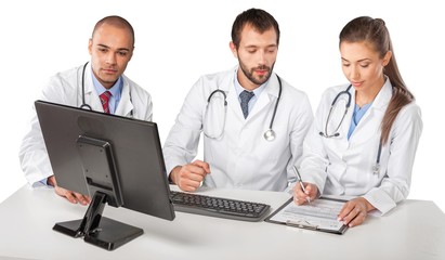 Fototapeta na wymiar Portrait of Doctors Looking at Computer Monitor and Writing on