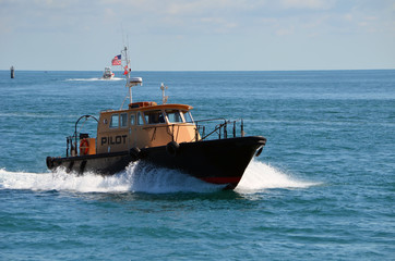 Pilot boat approaching Government Cut and heading towards the Port of Miami after guiding a container ship to the open ocean.