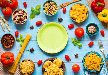 Different types of pasta with various types of vegetables, health or vegetarian concept on a wooden background,  Top view