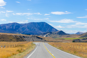 Rural Scene of Asphalt Road with Meadow and Mountain Range, South Island, New Zealand	