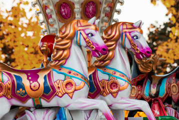 A colorful and vibrant vintage carousel (merry-go-round) with horses at the fairground.