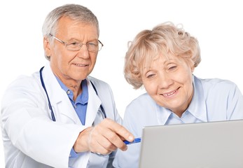 Portrait of a Mature Doctor with Patient Looking at Laptop