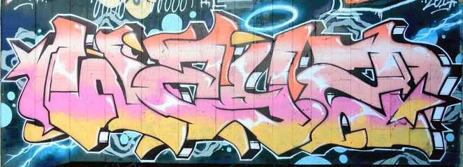 Ein Fragment eines detaillierten Graffitis einer Zeichnung, die mit Aerosolfarben auf einer Wand aus Betonfliesen erstellt wurde. Hintergrundbild der Straßenkunst in beigen und rosa Farbtönen © mehaniq41