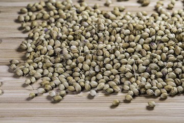 pile of dried coriander seeds on a bamboo cutting board background
